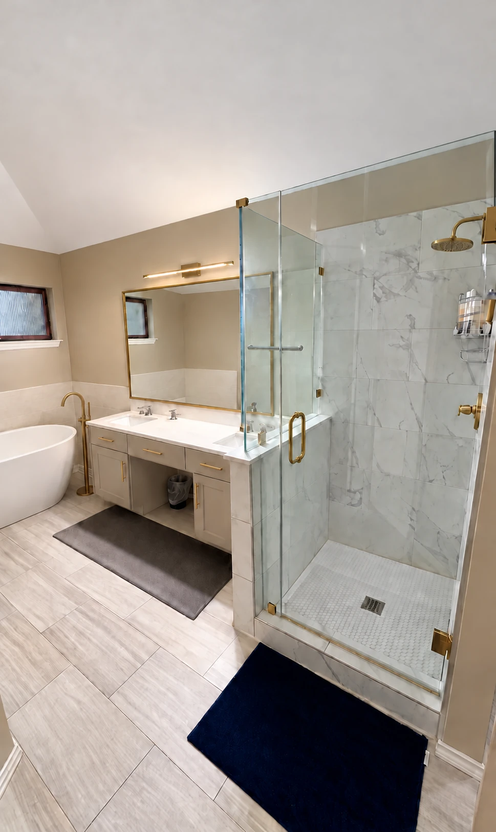 Completed Allen bathroom with a glass shower, marble-look tile, brass-toned fixtures, updated vanity and freestanding tub